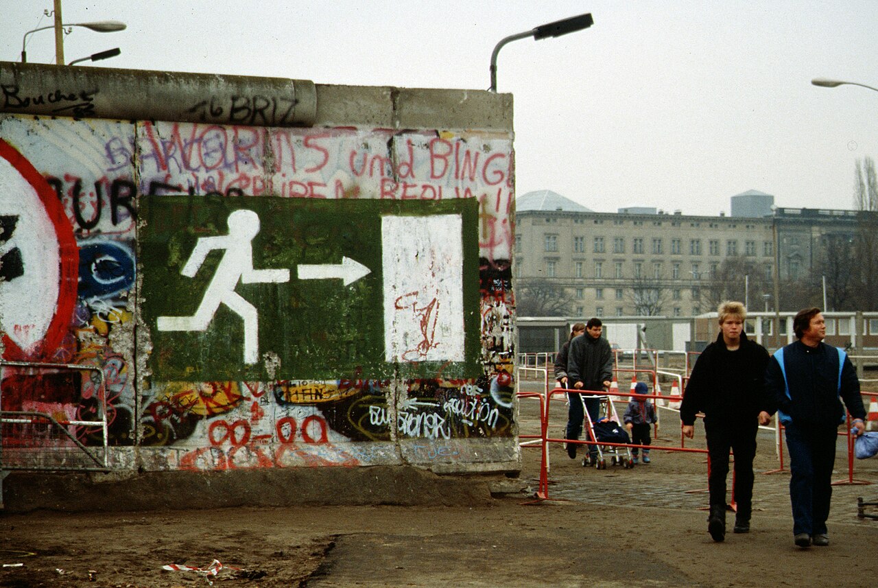 Crowds walking through openings in the Berlin Wall in 1989
